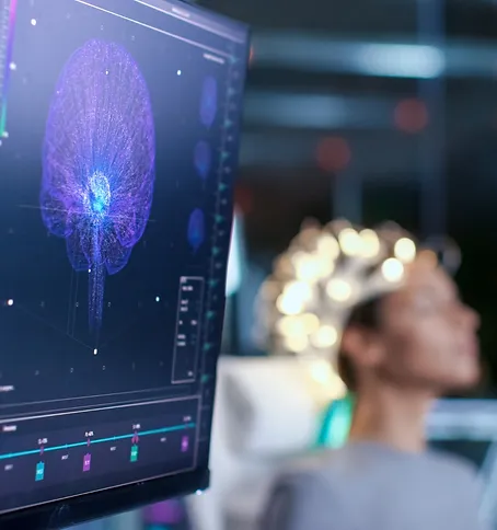 Hersenvisualisatie op een scherm naast iemand met meetapparatuur