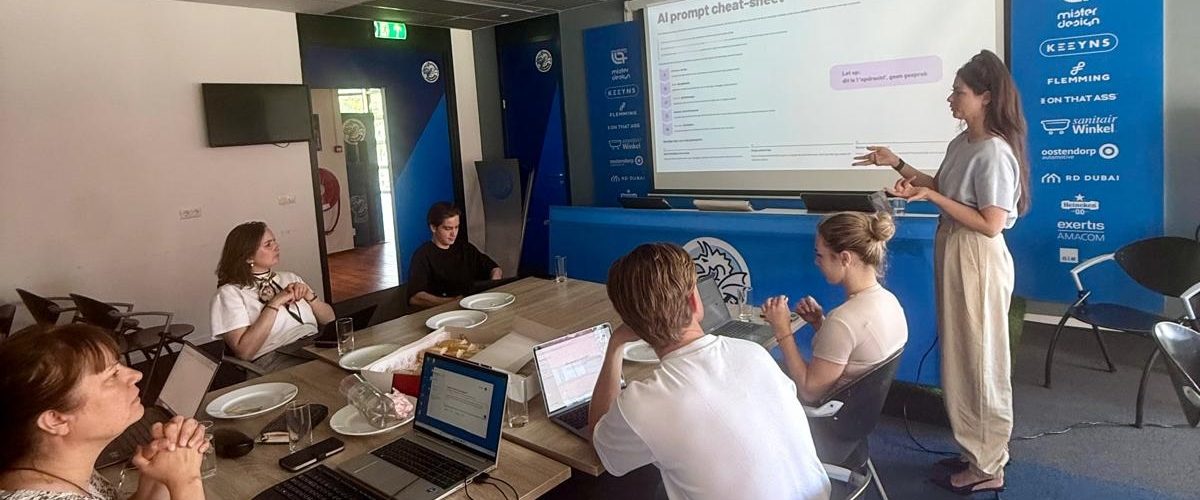 Karin geeft een basistraining AI bij FC Den Bosch, met op het scherm een AI prompt cheat-sheet.