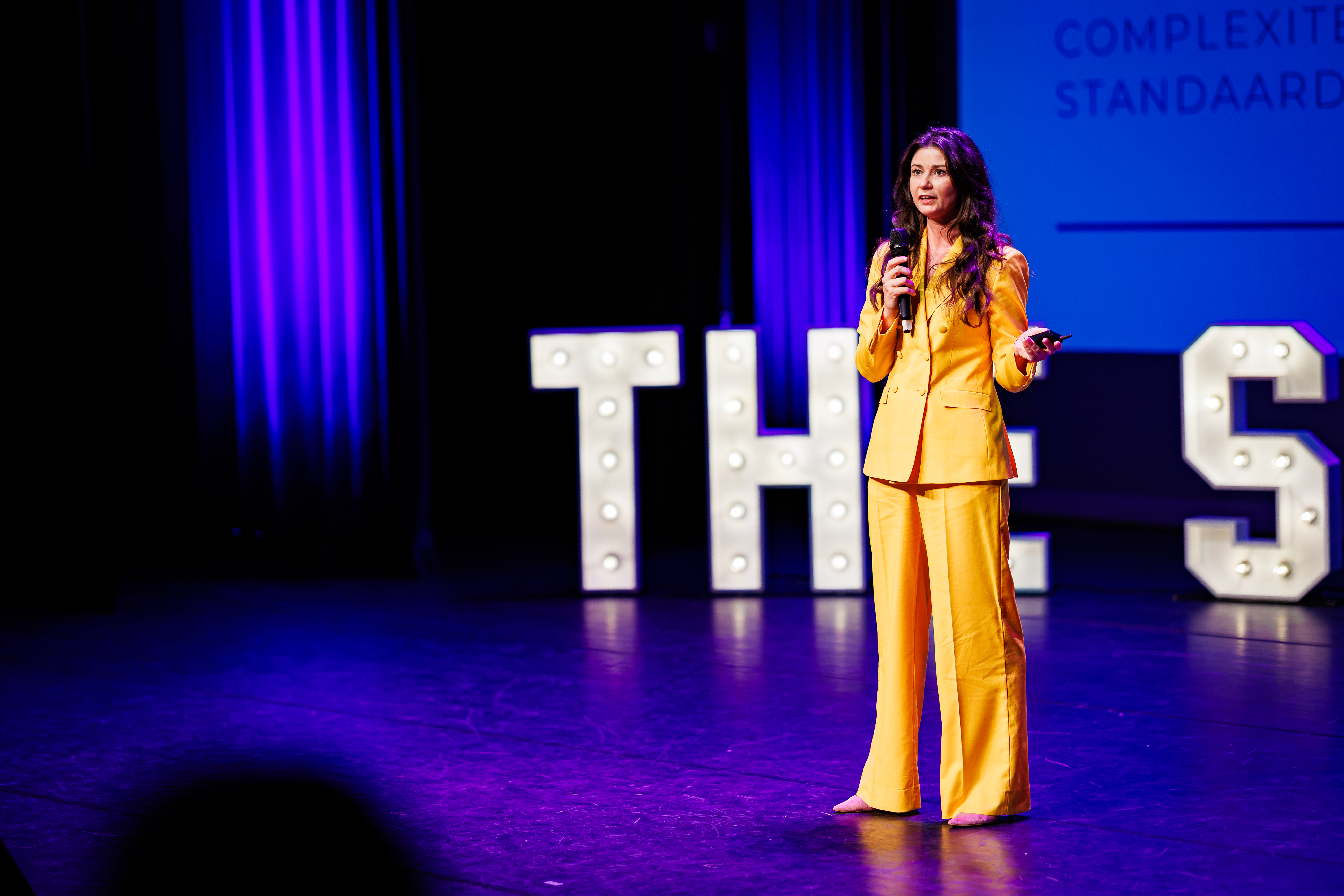 Karin op het podium tijdens een keynote of masterclass.